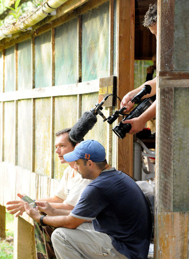 CAVU film crew interviewing someone outside a wooden building